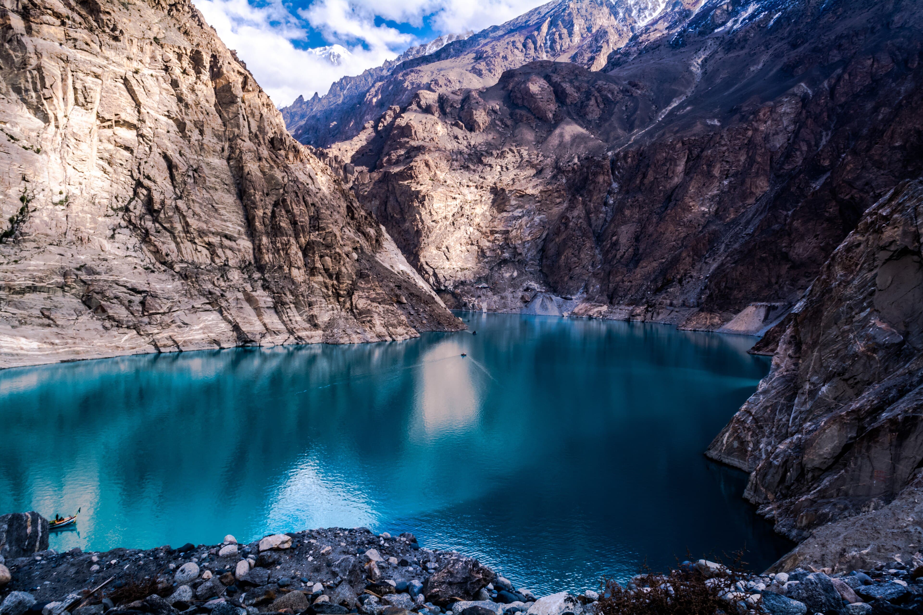 Turquoise water of Attabad Lake between steep Karakoram cliffs