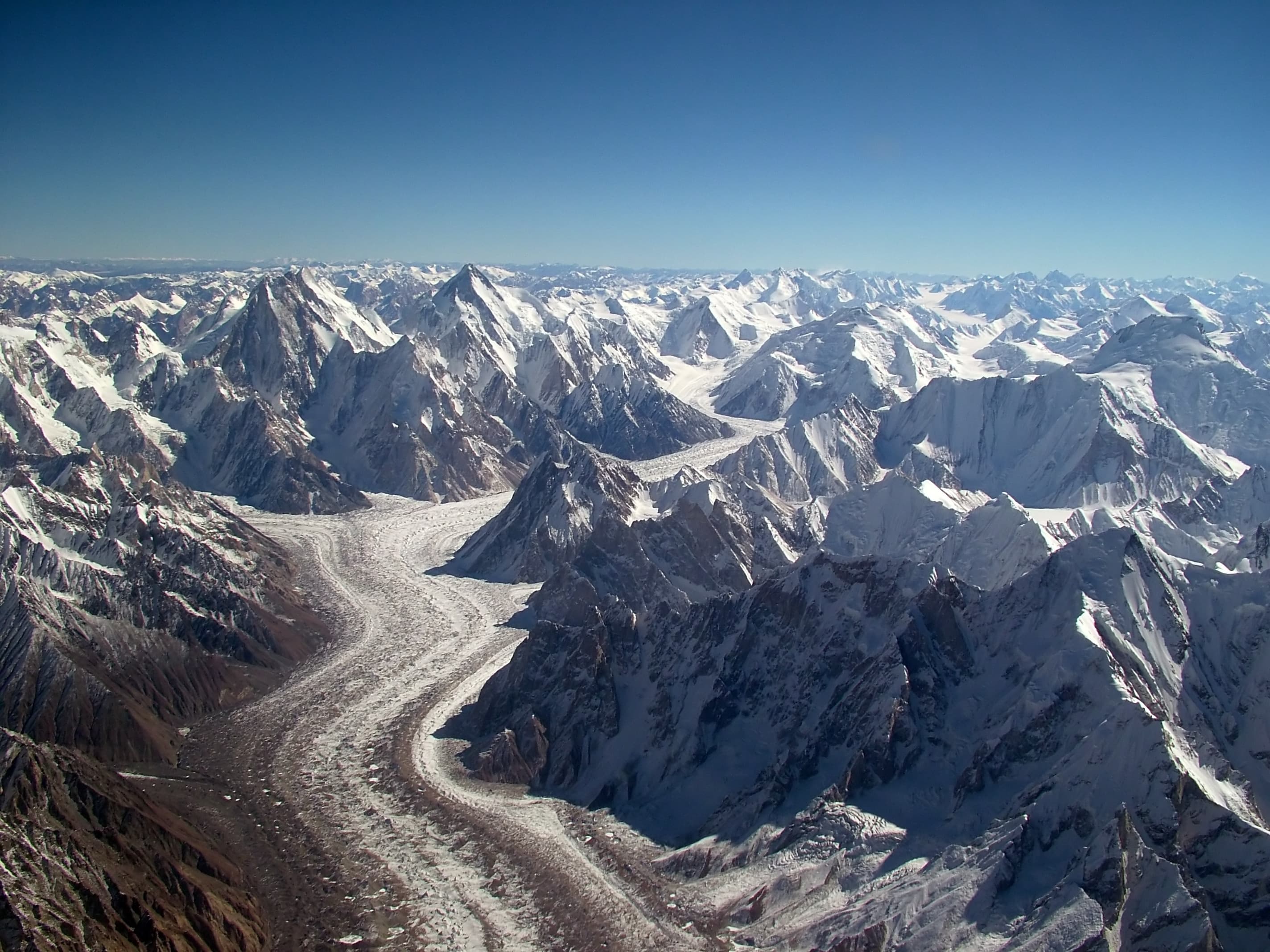 Trekkers on the Baltoro Glacier approaching Concordia with K2 ahead