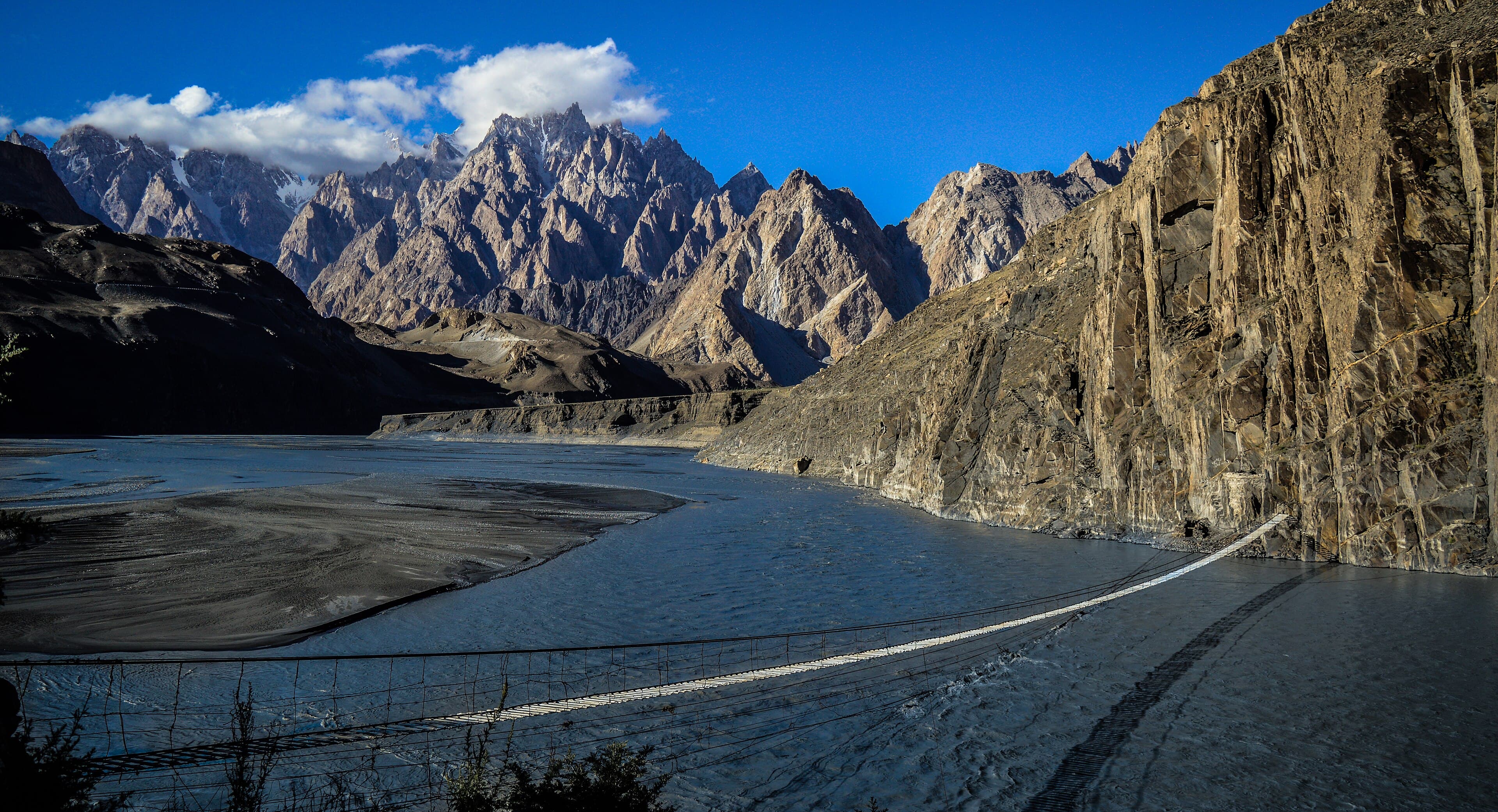 Traveler crossing the Hussaini Suspension Bridge over the Hunza River